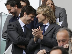 FILE -Juventus president Andrea Agnelli, left, is flanked by juventus former player Pavel Nedved during a Serie A soccer match between Juventus and Palermo, at the Juventus stadium, in Turin, Italy, May 5, 2013.