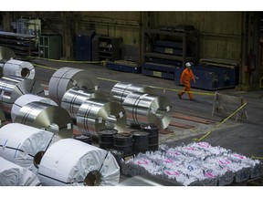 An employee passes in front of steel coils at a galvanizing mill in Hamilton, Ontario.
