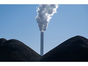 A smokestack stands behind piles of coal at the coal-fired Onyx Kraftwerk Farge power plant on March 10, 2022 near Bremen, Germany. The ongoing war in Ukraine, coupled with the possibility of energy-related sanctions against Russia, has caused international energy prices to jump. Over 50% of Germany's imports of coal come from Russia.