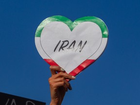 A woman holds a heart shaped sign in the colours of the Iranian flag as protesters rally during a 'No War on Iran' demonstration outside the Wilshire Federal Building in Los Angeles on June 18.