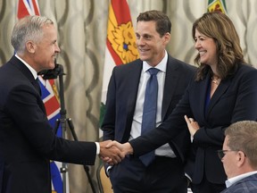 Canadian Prime Minister Mark Carney, left, greets Alberta Premier Danielle Smith, right, during the 2025 summer meetings of Canada's Premiers at Deerhurst Resort in Huntsville, Ont., on July 22, 2025.