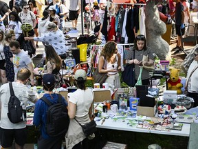 Bargain hunters check out tables of goods set up at the Great Glebe Garage Sale, in Ottawa, on Saturday, May 27, 2023.