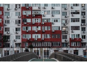 Air conditioning units hanging from a building in Beijing, China, on Thursday, Aug. 1, 2024. China's main grid operator will raise spending to a record to ease transmission bottlenecks, underscoring Beijing's push to boost renewable-energy usage and potentially benefiting metals including copper.