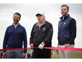 U.S. President Donald Trump speaks next to Donald Trump Jr. (L) and Eric Trump as they attend the ribbon-cutting ceremony at a new 18-hole course at Trump International Golf Links on July 29, 2025 in Balmedie, near Aberdeen, Scotland. President Trump is visiting Scotland in a trip that's part-vacation, part-work, as he stayed at his Trump Turnberry golf course, followed by Trump International Golf Links in Aberdeenshire, between July 25 to 29.
