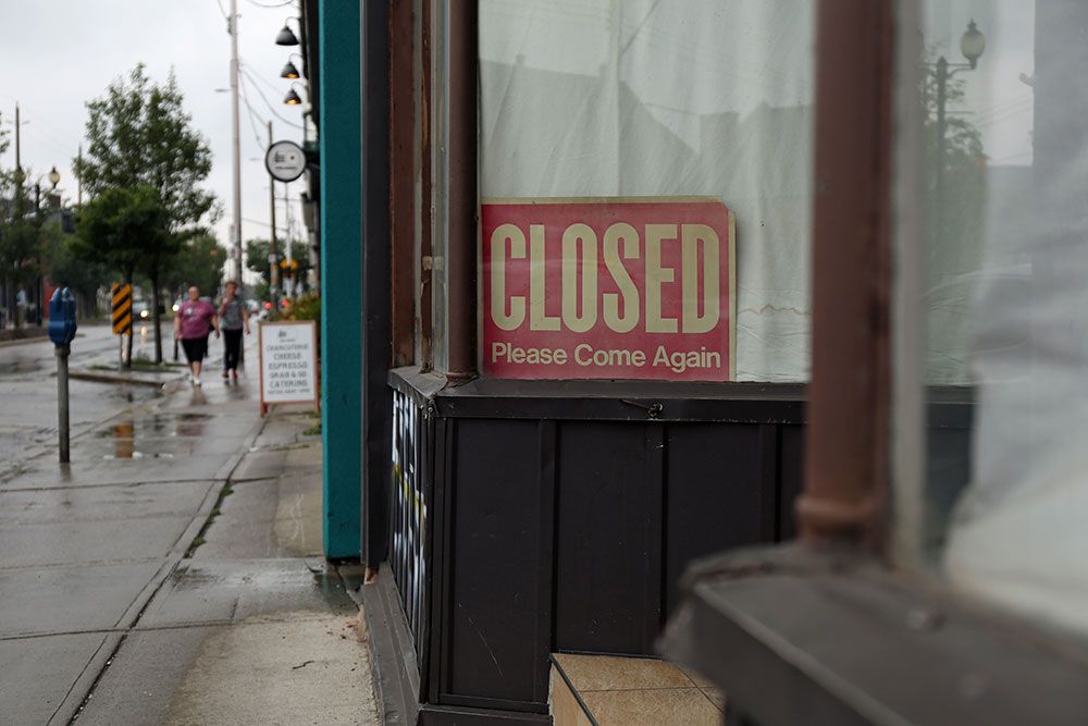 A yellowing closed sign sits in the window of an unused storefront on Barton St. E, in Hamilton.