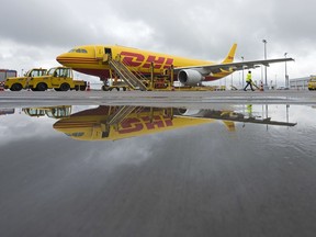 FILE -An DHL airplane reflects in the water during the opening of the new sorting center at its European DHL Express air freight hub in Schkeuditz near Leipzig, Germany, Oct. 12, 2016.