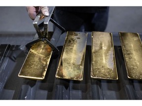 A worker removes cooled 12 kilogram gold ingots from their molds in the foundry at the Prioksky non-ferrous metals plant in Kasimov, Russia, on Thursday, Dec. 9, 2021. Bullion is heading for its first annual drop in three years as central banks start to dial back on pandemic-era stimulus.