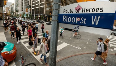 Pedestrians walk through the intersection of Bay St. And Bloor St. W. in Toronto.