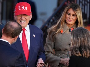 President Donald Trump, center left, and first lady Melania Trump, center right, greet families and hand out candy during a Halloween event on the South Lawn of the White House on Oct. 30, 2025, in Washington.