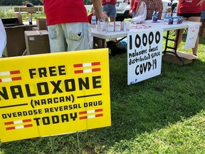 FILE - Signs are displayed at a tent during a health event June 26, 2021, in Charleston, W.Va.