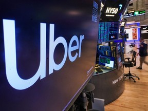 The logo for Uber is displayed above a trading post on the floor of the New York Stock Exchange, Monday, Oct. 20, 2025.