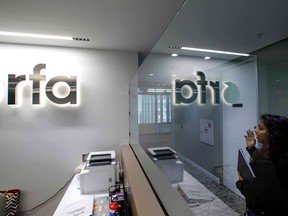 FILE - A woman walks past the empty receptionist desk at Radio Free Asia, April 1, 2025, in Washington.