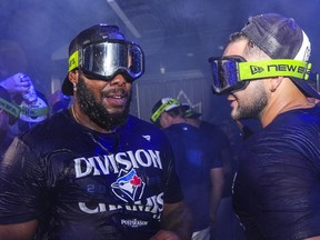 Toronto Blue Jays Vladimir Guerrero Jr. and Bo Bichette celebrate with teammates after winning the American League East Division title following MLB baseball action against the Tampa Bay Rays, in Toronto, Sunday, Sept. 28, 2025.