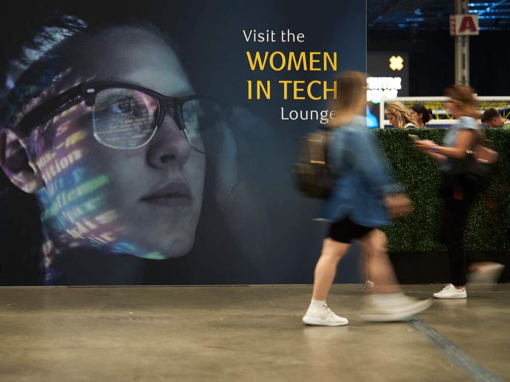 Women walk by the Women in Tech lounge at the Collision conference in Toronto, Ontario.