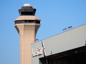 FILE - A control tower by an American Airlines hangar is shown at Dallas Fort Worth International Airport, Oct. 15, 2025, in DFW Airport, Texas.