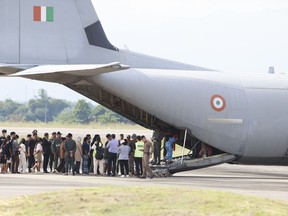India nationals, believed to have worked at scam center in Myanmar, board a plane at Thailand's Mae Sot International Airport in Tak, before being sent back to India, Thursday, Nov. 6, 2025.