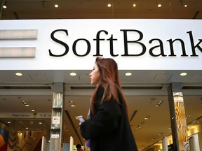 FILE - A woman walks in front of SoftBank store in Ginza shopping district in Tokyo, Jan. 20, 2020.