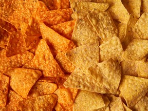 This image provided by PepsiCo shows from left, shows original Doritos Nacho cheese chips next to new Doritos without artificial colors or flavors.