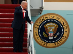 President Donald Trump gestures toward the media as he walks down the stairs of Air Force One upon his arrival at Joint Base Andrews, Md., Sunday, Nov. 9, 2025, after returning from his Mar-a-Lago estate in Palm Beach, Fla. and en route to an NFL football game between the Washington Commanders and the Detroit Lions.