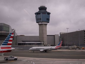 An American Eagle plane moves past the FAA Air Traffic Control tower at LaGuardia Airport (LGA) in the Queens borough of New York, Sunday, Nov. 9, 2025.