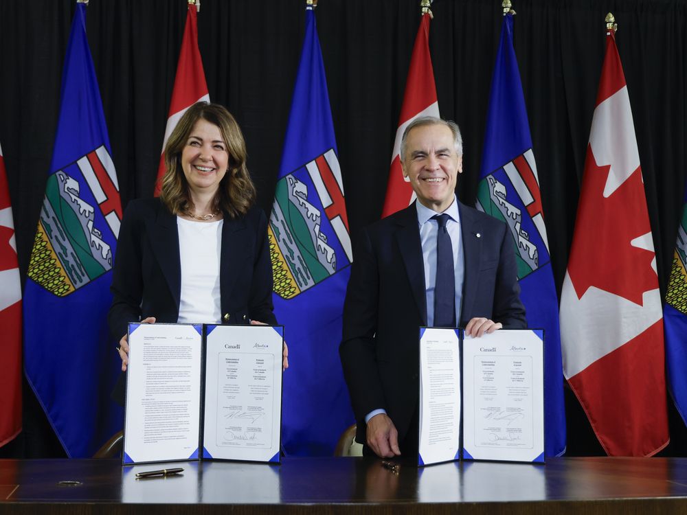 Prime Minister Mark Carney, right, signs a memorandum of understanding with Alberta Premier Danielle Smith in Calgary, Alta., Nov. 27.