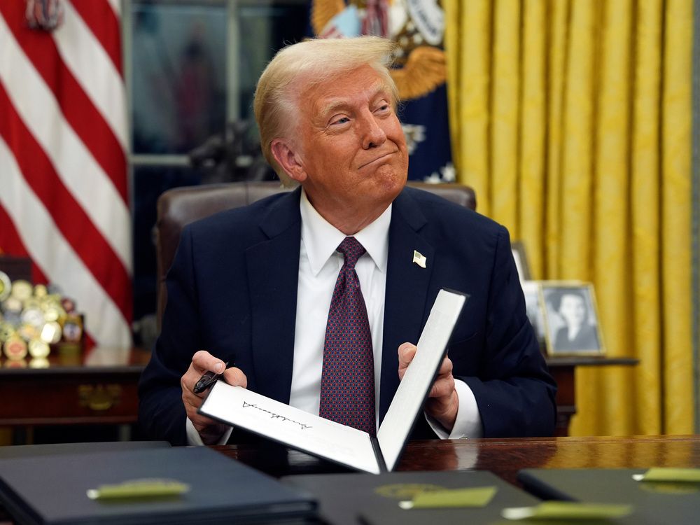 U.S. President Donald Trump signs executive orders in the Oval Office of the White House in Washington, D.C.