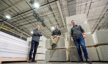 Trusscore's CEO Dave Caputo, left, president Steve Bosman, centre, Joel Koops, right, executive vice president pose for a shot in their warehouse during the pandemic.