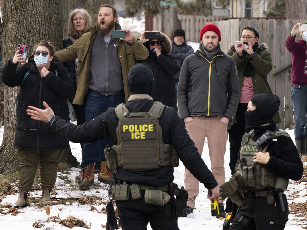 Observers film ICE agents as they hold a perimeter after one of their vehicles got a flat tire on Penn Avenue on February 5, 2026 in Minneapolis, Minnesota.