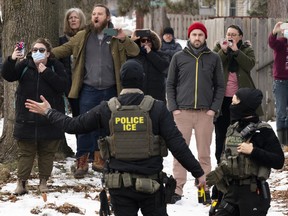 Observers film ICE agents as they hold a perimeter after one of their vehicles got a flat tire on Penn Avenue on February 5, 2026 in Minneapolis, Minnesota.