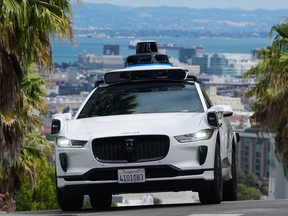 A Waymo car drives up a hill in San Francisco