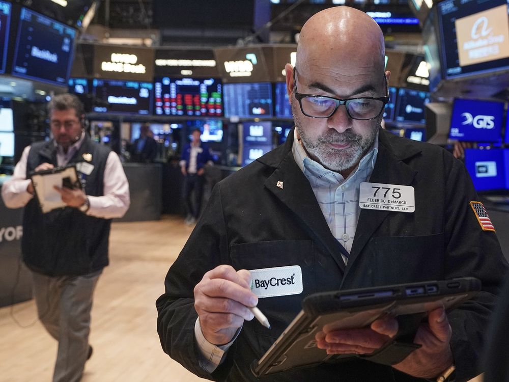 Trader Fred Demarco, right, works on the floor of the New York Stock Exchange, Friday, Feb. 13, 2026, in New York