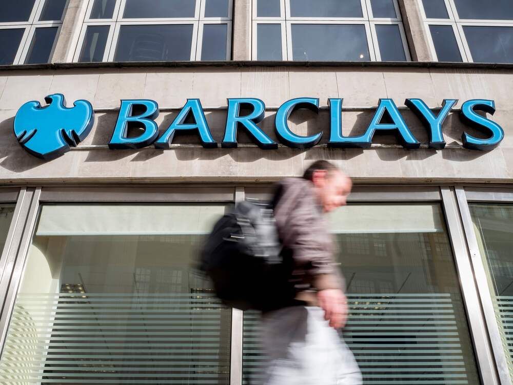 A pedestrian walking past a branch of Barclays bank in central London.