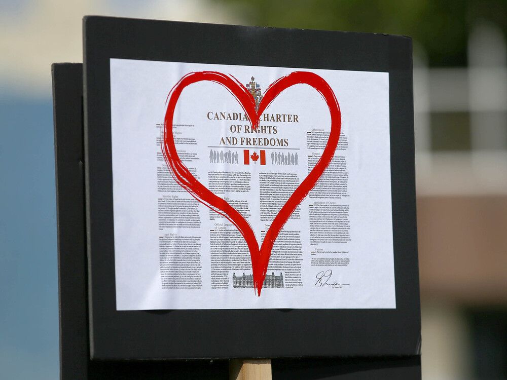 A sign showing the Canadian Charter of Rights and Freedoms is shown during a rally at Central Memorial Park in downtown Calgary.