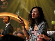 A woman smokes a cigar during a humidor auction held as part of the closing ceremony of the XXV Habanos Festival in Havana
