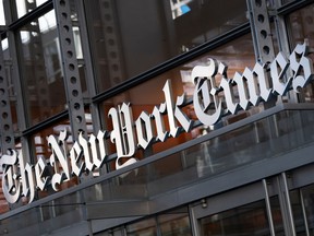 A sign for The New York Times is displayed above the entrance to its building in New York