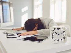 Tired business woman lies asleep at the desk workplace in the office.