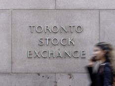 A pedestrian walks past Toronto Stock Exchange signage in Toronto’s Financial District