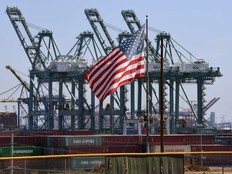 The U.S. flag flies over Chinese shipping containers that were unloaded at the Port of Long Beach, in Los Angeles County