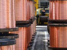 An employee works near rolls of copper wires at the Nexans manufacture in Lens, northern France
