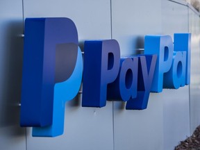Pedestrians walk past PayPal Holdings Inc. signage outside the company's headquarters in San Jose, California
