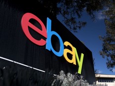 A pedestrian walks past signage for eBay Inc., standing in front of the company's headquarters in San Jose, California, U.S.