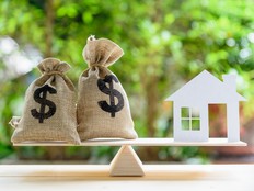 House paper model , US dollar hessian bags on a wood balance scale, depicts a homeowner or a borrower turns properties into cash.