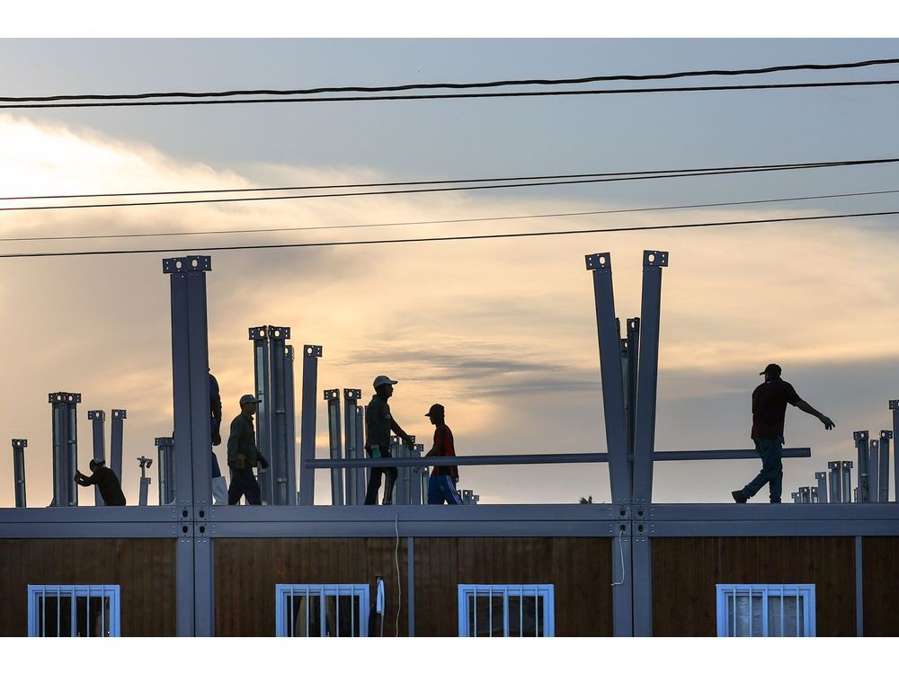 Construction workers at a site where a prefabricated school is being built in Georgetown.