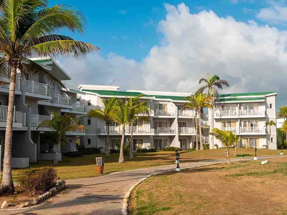 Tryp Cayo Coco. The hotel houses are set against a background of blue sky, tall palms and green plants. Cayo Coco, Cuba. Getty Images