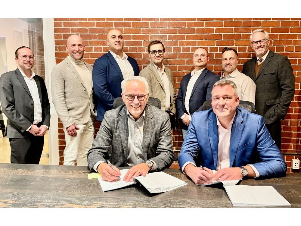 Martin Jacques, COO at Pomerleau, and Eric Desaulniers, President & CEO of NMG, officialize a new collaboration chapter in presence of key team members.