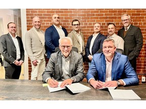 Martin Jacques, COO at Pomerleau, and Eric Desaulniers, President & CEO of NMG, officialize a new collaboration chapter in presence of key team members.
