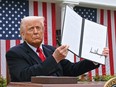 U.S. President Donald Trump holds a signed executive order after delivering remarks on reciprocal tariffs during an event in the Rose Garden at the White House in Washington, D.C., on April 2, 2025.