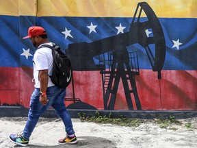 A man walks past a mural depicting an oil pumpjack on a Venezuelan flag in Caracas on January 15, 2026.