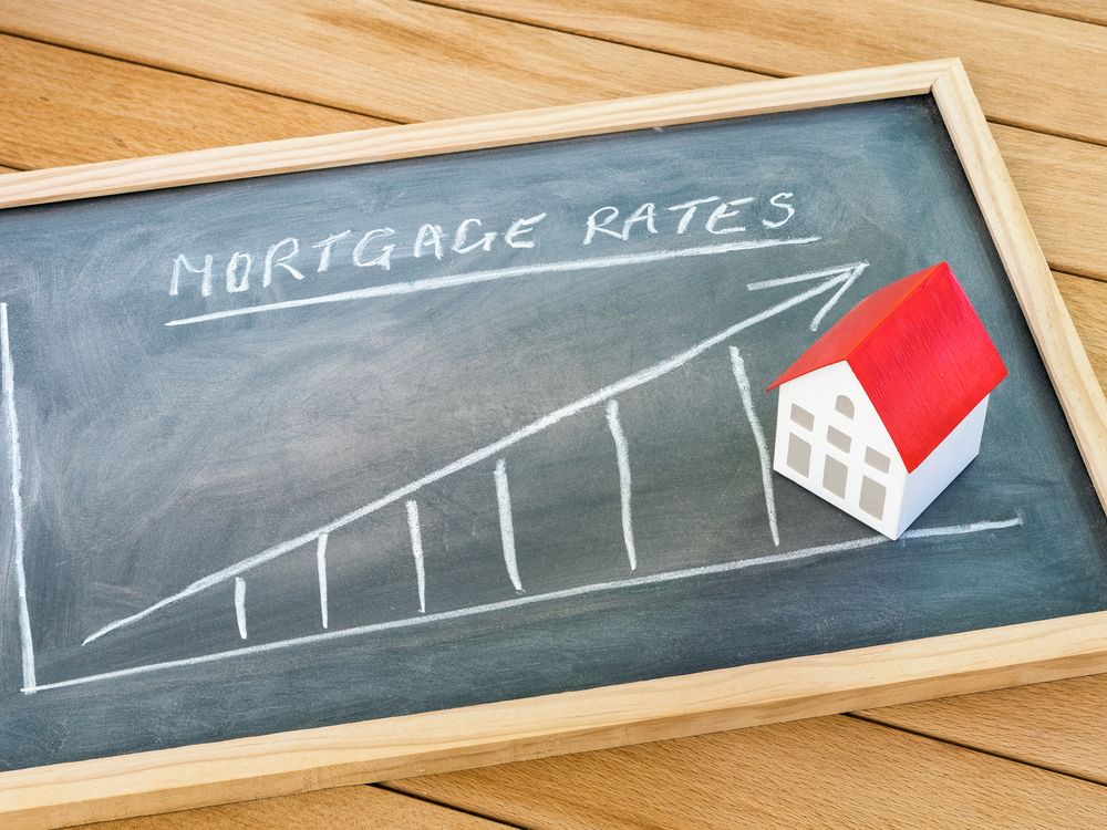 Graph representing the rise in mortgage interest rates drawn on a chalkboard lying on a wooden table.