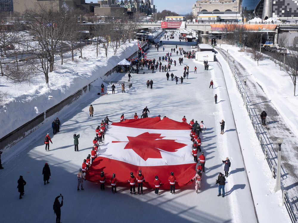 Local youth skate with a large Canadian flag on the Rideau Canal to launch celebrations for the 60th Anniversary of the National Flag of Canada Day on Feb. 14, 2025 in Ottawa.